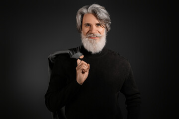 Portrait of handsome mature bearded man on dark background