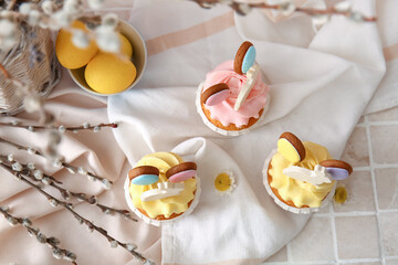 Obraz na płótnie Canvas Tasty Easter cupcakes with eggs and willow branches on color background