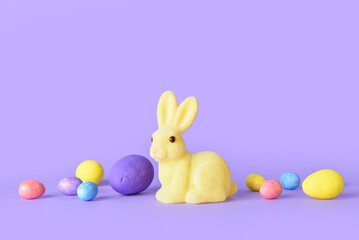 Cute Easter bunny and eggs on purple background