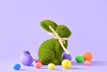 Easter bunny and painted eggs on color background
