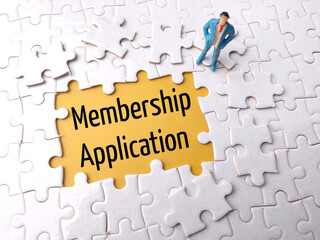 Top view miniature people with text Membership Application on a white puzzle background.