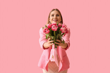 Beautiful woman with bouquet of tulips on pink background. International Women's Day