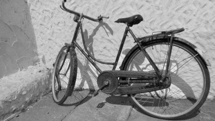 Fototapeta na wymiar Old antique bicycle sitting up against a irish cottage