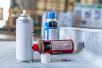 Cans of spray Penetrant Testing on on material steel and blur factory in background