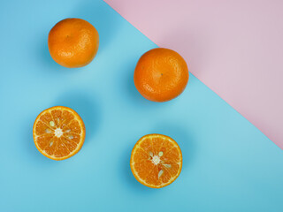 Creative concept made from oranges on blue and pink pastel background. healthy and minimal fruit concept