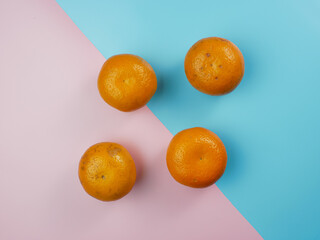 Creative concept made from oranges on blue and pink pastel background. healthy and minimal fruit concept