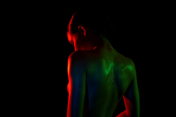 Naked woman silhouette in color lights. graceful sexy girl