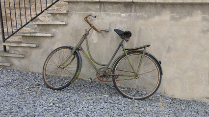 Old antique bicycle sitting up against a irish cottage