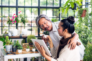 Senior couple asian family having good time using tablet computer together.Happy elderly husband and wife checking social media and reading news or shopping online while sitting at home