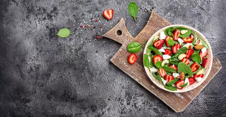 Diet menu. Healthy salad of fresh strawberry, spinach leaves, nuts and feta cheese, balsamic vinegar. Vegan food. Long banner format. top view