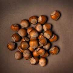 Bunch of hazelnut on brown background. View from above