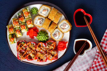 Rolls set served on plate on dark blue background. Japanese menu sushi dinner for two. Horizontal top view from above