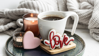 A cozy still life for Valentine's Day with a cup, decor details and gingerbread.