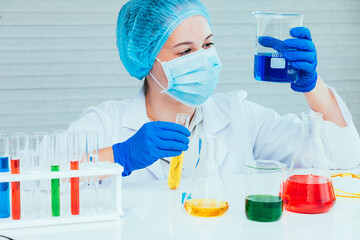 Scientist in uniform holding beaker and test tube have chemical liquid for testing chemical reaction.