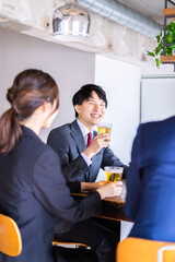 お酒を飲みながら話すビジネスパーソン