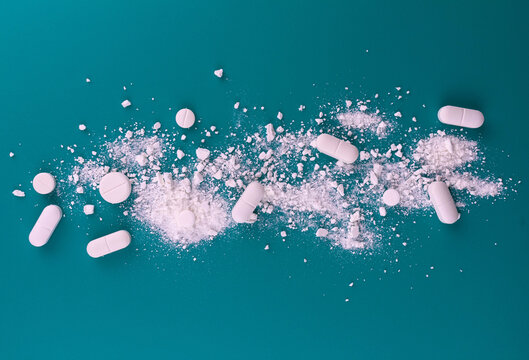 Medical background and s of crushed pills on a blue background