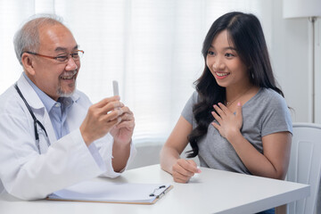 happy and glad Asian pregnancy check with doctor looking at pregnancy test equipment