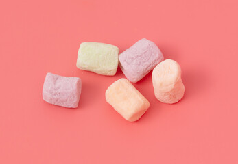 Multicolored candies on a pink background. Close-up