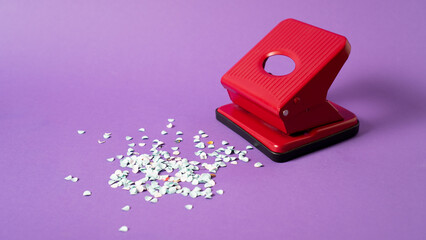 Red confetti maker. Hole puncher machine. Paper punch sprinkle. Hole punch art. Red puncher on...