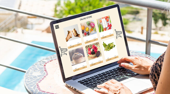 Close up woman sitting and ordering food online on laptop computer in add to cart function webpage.