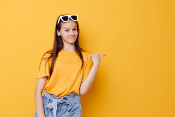 Fototapeta premium young beautiful woman fashion in yellow t-shirt denim shorts yellow background