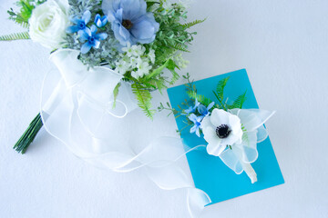 幸せを願う白と青のウェディングブーケとブートニア（アネモネ、バラ、ラナンキュラス、ブルースターなどの造花）