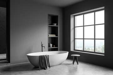 Dark bathroom interior with bathtub, panoramic window with countryside view