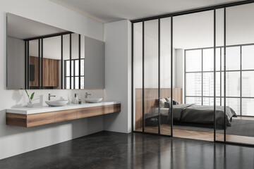 Light hotel interior with sink and bed near window with city view