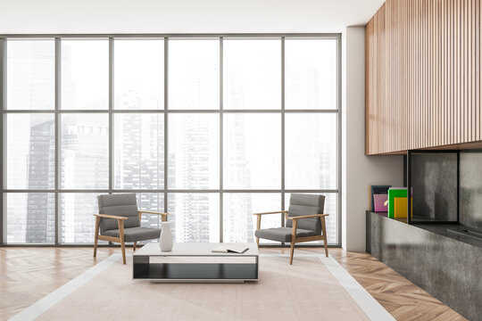 Light living room interior with seats and coffee table near window