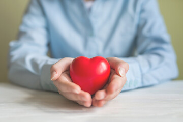 girl hands holding red heart, healthcare, love, organ donation, mindfulness, wellbeing, family insurance and CSR concept, World Heart Day, World Health Day