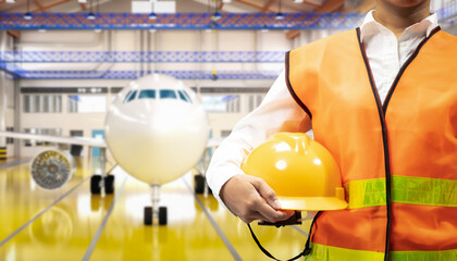 Asian engineer or technician with airplane in hangar