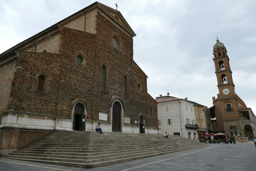 Fototapeta na wymiar St. Peter Cathedral in Faenza, the facade unfinished built by rough brick, and with in front the staircase and the square