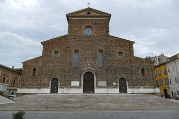 St. Peter Cathedral in Faenza, the facade unfinished built by rough brick, and with in front the staircase and the square