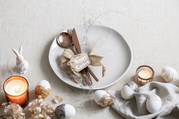 Festive Easter table setting with decor details on white table.