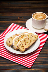 Slices of Traditional Christmas stollen cake with marzipan and dried fruit and cup of coffee