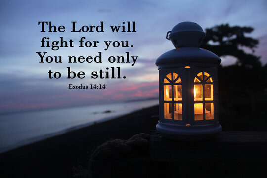 Bible verse inspirational quote - The Lord will fight for you. You need only to be still. Exodus 14:14 With white lantern and candle light inside in the night after sunset in the beach.