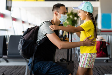 Father and daughter wearing protective medical masks use disinfectant at the airport or mall. Virus and illness protection