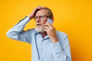 Portrait elderly man talking on the phone posing close-up isolated background