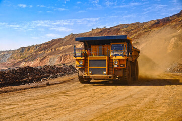  Mining dump truck transports rock, iron ore along the side of the quarry. © Yevhen