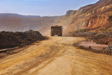  Mining dump truck transports rock, iron ore along the side of the quarry. © Yevhen