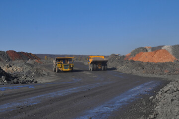  Mining dump truck transports rock, iron ore along the side of the quarry. © Yevhen