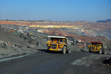  Mining dump truck transports rock, iron ore along the side of the quarry. © Yevhen