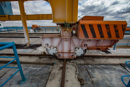 Wheels and bogie of gantry crane on dam. Rusted rails, concrete floor. Kazaly city, Kyzylorda region, Kazakhstan.