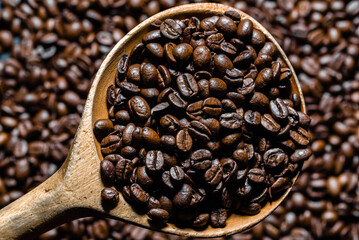 Fototapeta premium Freshly roasted coffee beans in spoon. Coffee background.