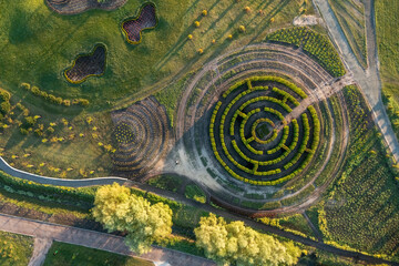 Aerial view of the green flower beds in the park in the form of circles, a labyrinth and other figures. drone shot. natural summer spring background.