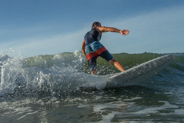 Young surfer with rides the tropical wave.