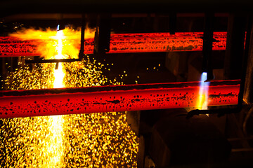 Manufacturing of mild steel square bar on continuous casting machine line. Cutting bars by gas torch. Metal sparks.