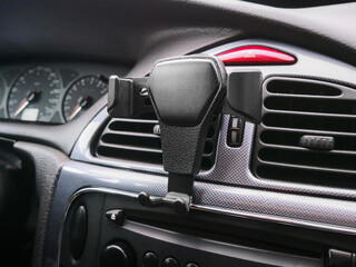 Automatic gravity phone holder attached to the ventilation grille in the car, close up