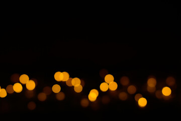 Golden glitter bokeh lights on black background, unfocused. Party, event, Festive, birthday background