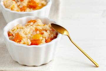 Porridge with pumpkin and pumpkin seeds on white table